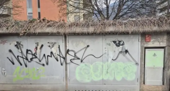 Imbratta muro e contatore con scritte contro la polizia: denunciata una 23enne anarchica a Bolzano