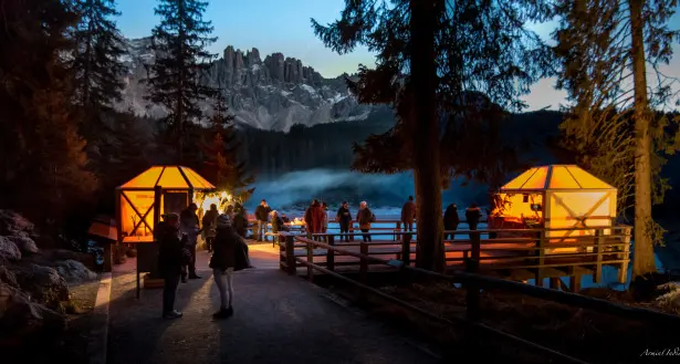Il Mercatino di Natale nella magia del Lago di Carezza, le casette sono a forma di lanterna