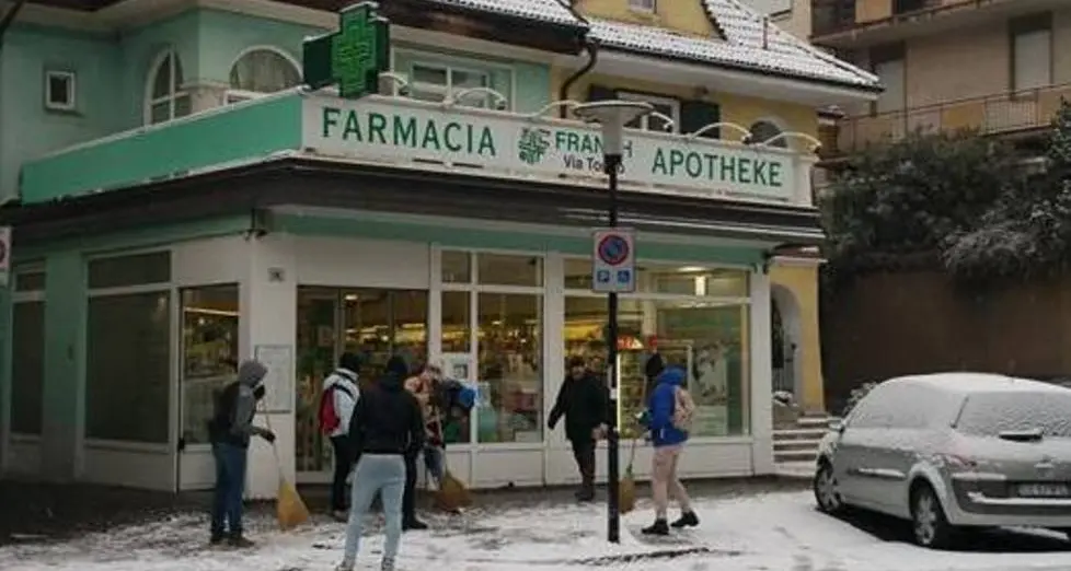 Via Torino, i migranti spalano il marciapiede