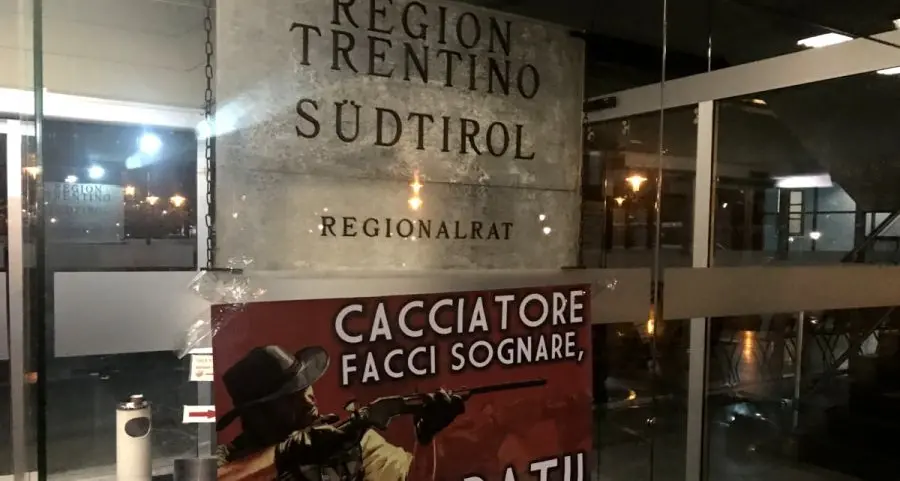 Manifesto contro i cacciatori sulla vetrata del palazzo della Regione
