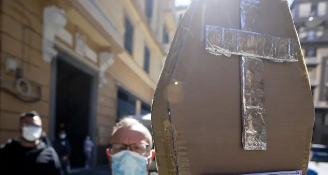 Ambulanti in piazza con bara di cartone