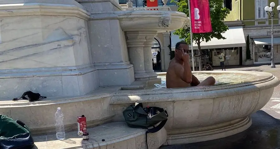 Bagno in fontana e balletto in slip in piazza Walther