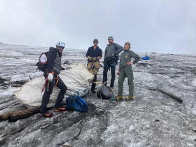 Volontari e soccorritori in alta montagna raccolgono rifiuti tra rocce e neve al Passo dello Stelvio