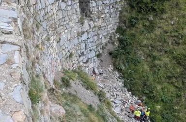 Strada di montagna con torrente asciutto, area collinare, curve e vegetazione circostante, immagine di approfondimento