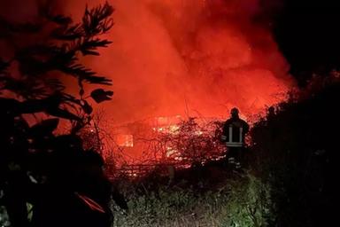 Strada rurale calabrese con erba alta e fumo, incendio boschivo sullo sfondo, immagine di approfondimento