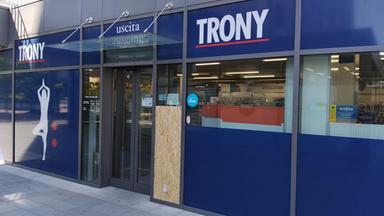 Interno di negozio Trony con vetrina sfondata e ripiani semivuoti dopo furto notturno