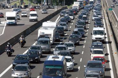 Autostrada congestionata con traffico fermo in colonna verso sud, segnali di coda visibili in lontananza