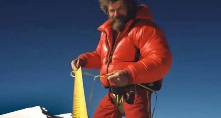 Messner e il record perso, foto ironica dell’alpinista con il metro a nastro in vetta